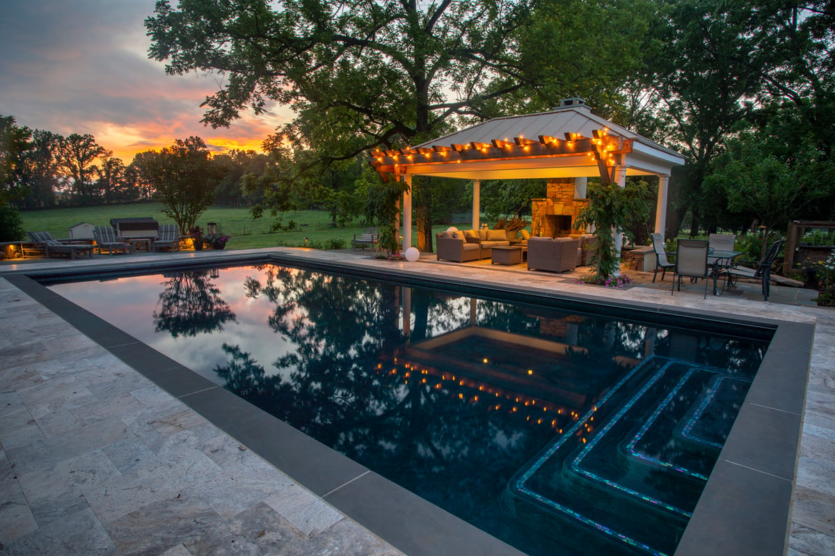 pool with lighting and fireplace